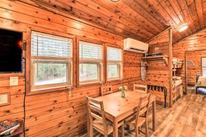 a dining room with a table in a wooden cabin at Charming New Bern Log Cabin - Pets Welcome! in New Bern