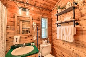 a bathroom with a sink and a toilet in a log cabin at Charming New Bern Log Cabin - Pets Welcome! in New Bern +16 photos