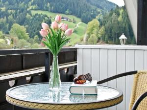 eine Vase rosa Tulpen, die auf einem Tisch mit einem Buch sitzt in der Unterkunft Landpension Am Sommerhang in Bad Rippoldsau