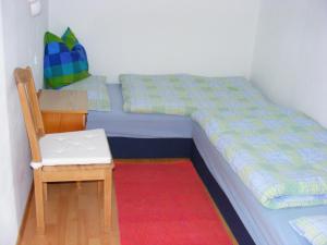 ein Schlafzimmer mit einem Bett, einem Stuhl und einem Schreibtisch in der Unterkunft Haus Rosenegg in Werfenweng