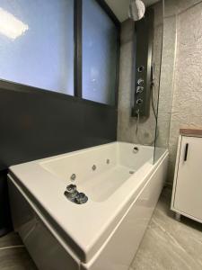 a white bath tub in a bathroom with a window at Eva Otel in Tuzla