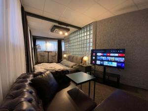 a living room with a couch and a tv at Eva Otel in Tuzla