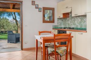 a kitchen with a table and two chairs and a table at Appartamento in Villa in campagna in Olbia
