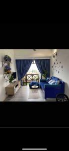 a living room with a blue couch and a window at Century Mahkota Apartments in Melaka