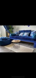 a blue couch in a living room with a table at Century Mahkota Apartments in Melaka