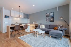 a living room and kitchen with a couch and a table at ROKU by H2 Life in Niseko