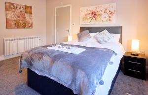 a bedroom with a large bed with a blanket on it at OYO Studiotel Hartlepool in Hartlepool