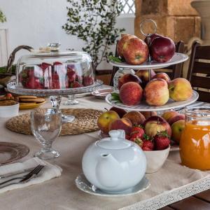 einen Tisch mit Obstteller und einer Teekanne in der Unterkunft Li Brilli in Felline