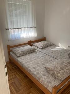 two twin beds in a bedroom with a window at Apartman Jana Apatin in Apatin