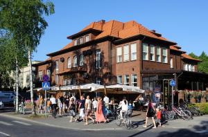 a group of people crossing a street in front of a building at Hotel Villa Wesset in Pärnu