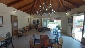 una sala da pranzo con tavoli, sedie e lampadario a braccio di Mirabelle Hotel ad Argásion
