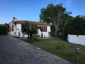 a white house with a palm tree in the yard at Villa dei Pioppi in Fontane Bianche