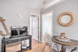 a living room with a tv and a table and a mirror at Bright Belmar Cottage Less Than Half Mi to Boardwalk! in Belmar