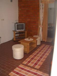 Apartment Dario في Gruda: غرفة معيشة مع كرسيين وتلفزيون