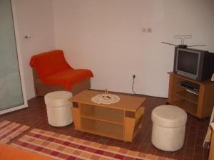 Apartment Dario في Gruda: غرفة معيشة مع كرسي احمر وتلفزيون