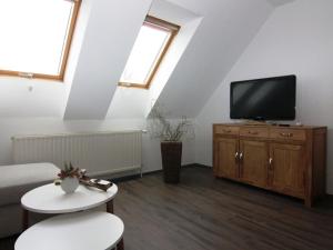 a living room with a couch and a tv on a cabinet at Apartment at the Castle Square in Wolgast