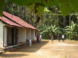 un grupo de personas parados fuera de un edificio en Raj Estate Stay, en Madikeri