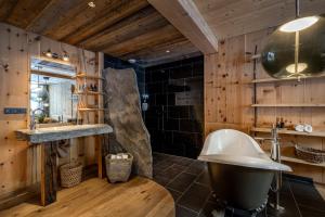 a bathroom with a large tub and a sink at mama thresl in Leogang