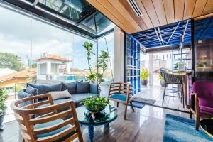 a living room with a couch and a table and chairs at Tien Hotel Georgetown in George Town