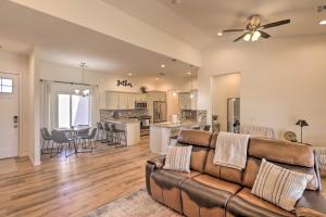 a living room with a couch and a kitchen at Bright Home with Yard, 4 Mi to Colorado River! in Fort Mohave