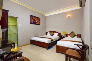 ein Hotelzimmer mit 2 Betten und einem TV in der Unterkunft VINH MINH HOTEL in Nha Trang
