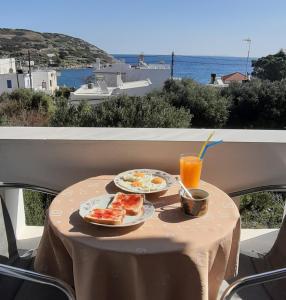 a table with two plates of food and a glass of orange juice at Despina Studios in Mochlos