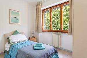 um quarto com uma cama e uma janela em Villa Le Maree di Tonfano em Pietrasanta