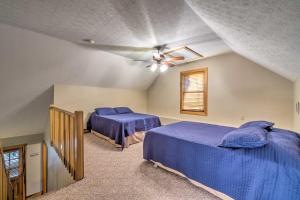 Un dormitorio con dos camas y un ventilador de techo. en Quaint Lakeside Cabin with Pond and Fire Pit!, en Lewisburg