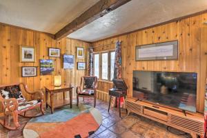 ein Wohnzimmer mit einem großen TV und Holzwänden in der Unterkunft Lake Cabin with King Bed, Foodie Kitchen, and Views in Twin Lakes