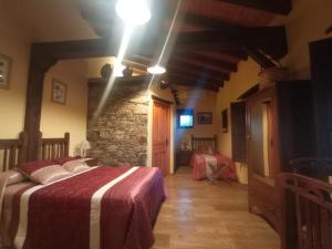 a bedroom with two beds and a stone wall at La Alquería de Mámoles in Mámoles