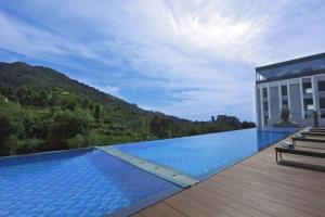 a large swimming pool next to a building at Grand ASTON Puncak Hotel & Resort in Puncak