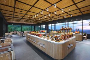 a restaurant with a counter with food on it at Grand ASTON Puncak Hotel & Resort in Puncak