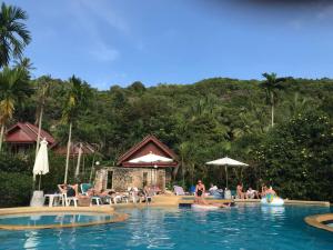 een groep mensen in het zwembad van een resort bij Tanouy Garden in Baan Khai