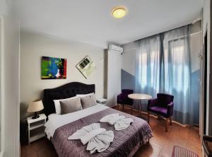 een slaapkamer met een bed met 2 kussens erop bij Guest House De Rada in Tirana