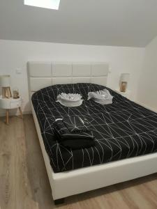 a bed with a black comforter and a black bag on it at Le125 in Saultain