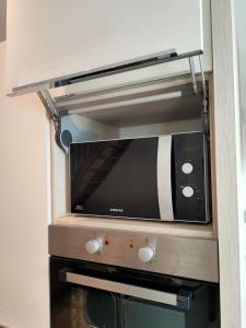 a black and white microwave oven in a kitchen at Le125 in Saultain