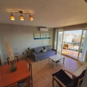 a living room with a blue couch and a table at Precioso apartamento en L'hospitalet de l'infant in Hospitalet de l'Infant