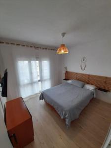 a bedroom with a bed and a wooden floor at Precioso apartamento en L'hospitalet de l'infant in Hospitalet de l'Infant