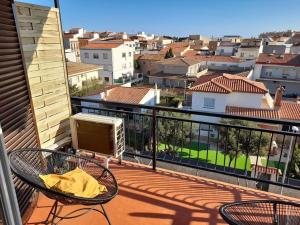a balcony with two chairs and a view of a city at Precioso apartamento en L'hospitalet de l'infant in Hospitalet de l'Infant