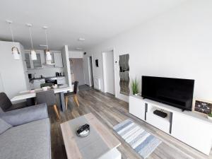 a living room with a couch and a tv at Juhar Apartman in Kőszeg