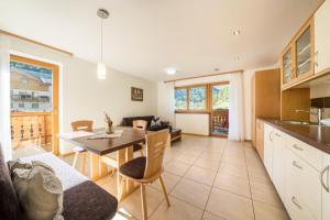 a kitchen and living room with a table and chairs at Fewo Sonnenuntergang - Zeppichl in Pfelders +21 photos