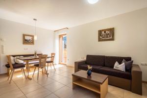 a living room with a couch and a table at Fewo Sonnenuntergang - Zeppichl in Pfelders