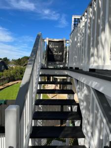 uma escada que leva a uma casa com uma cerca branca em The Jazz Loft em Onetangi