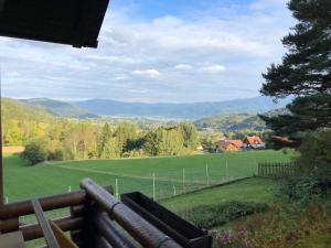 uma vista para um campo a partir de um alpendre com um banco em Ferienhaus Parschlug 