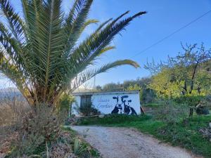 a sign with a palm tree next to a dirt road at Cortijo Vacas Gordas Villas in Castell de Ferro