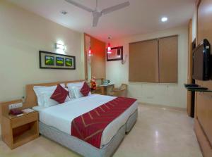 1 dormitorio con 1 cama y TV de pantalla plana en Hotel Metropolitan, en Nueva Delhi