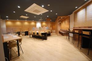 a restaurant with tables and chairs in a room at Sun Hotel Kokubu Kagoshima in Kirishima