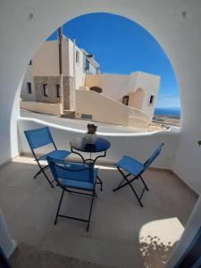 a table and chairs on the balcony of a house at Atlantida Spacious Flat in Fira