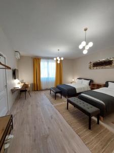 a hotel room with two beds and a desk and a table at Mandarin Premium Apartments in Târgu-Mureş