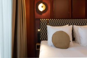 a bed with a wooden headboard and white pillows at Hotel de Timmerfabriek I Kloeg Collection in Vlissingen +65 photos